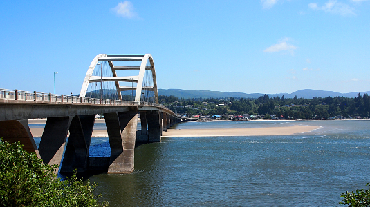 [Viewing the bridge from just beside it on the northern edge. A sandbar runs under it and extends into the bay.]